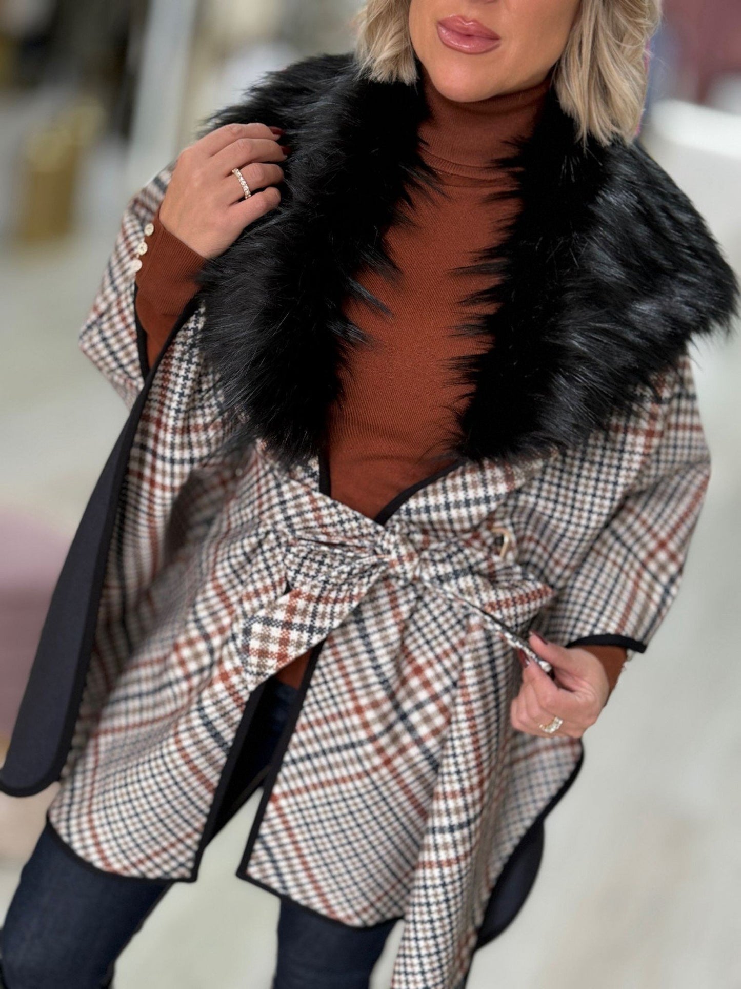 Capa com padrão xadrez e gola de pêlo