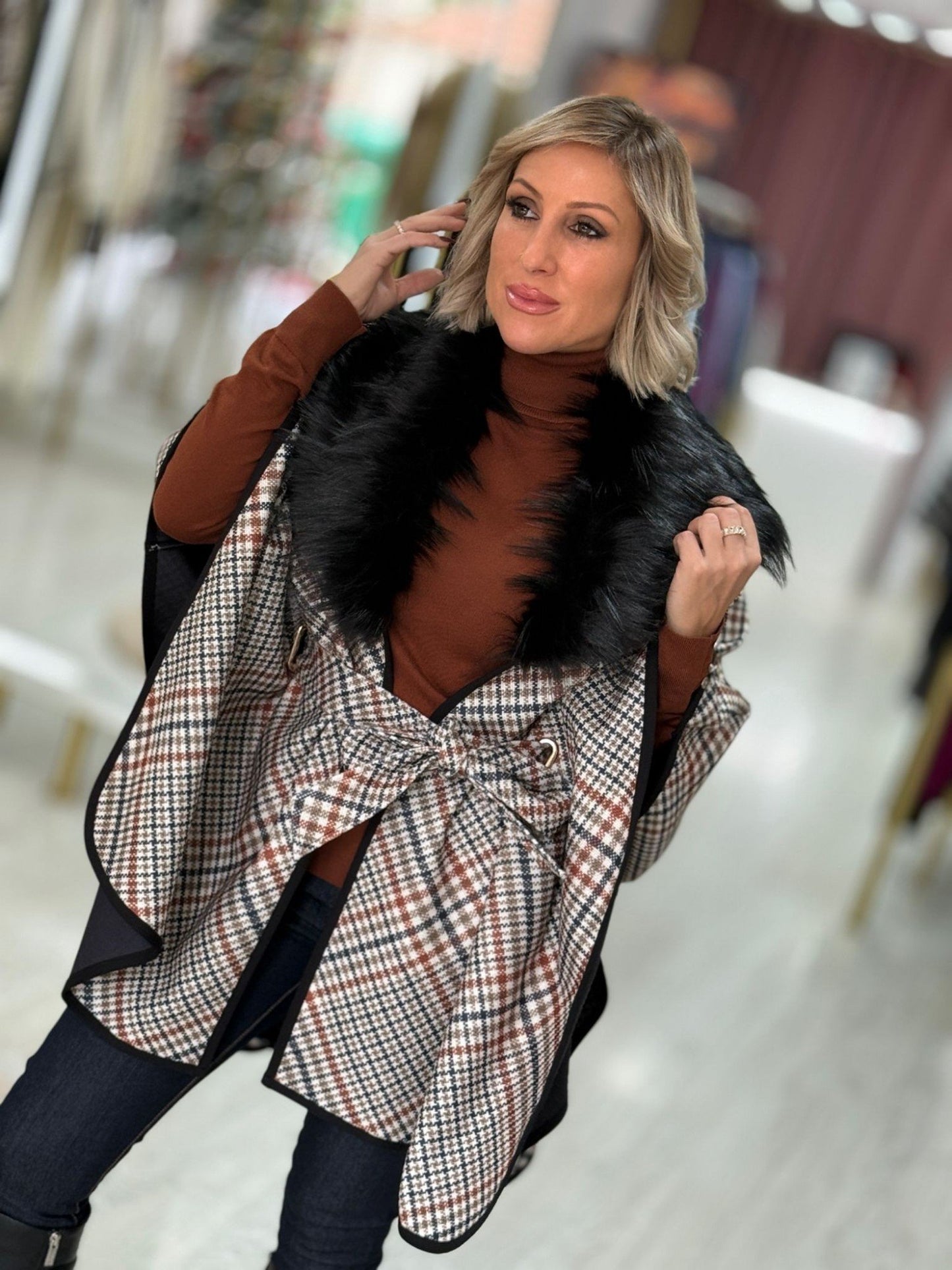 Capa com padrão xadrez e gola de pêlo